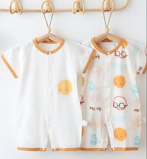 Children's clothing with cartoon designs on hangers against a white wall.