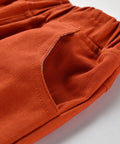 Close-up of orange pants with a pocket on a white background