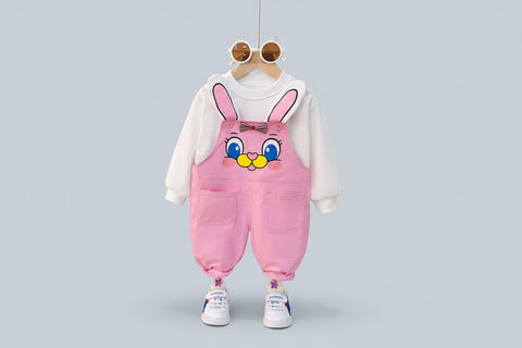 Children's outfit with pink bunny overalls and white hoodie on a hanger.