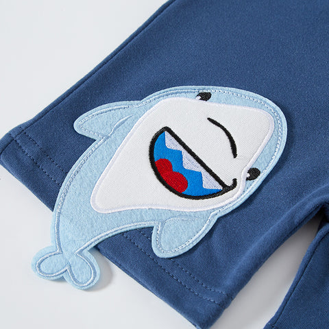 Blue pants with a shark patch on a light gray background
