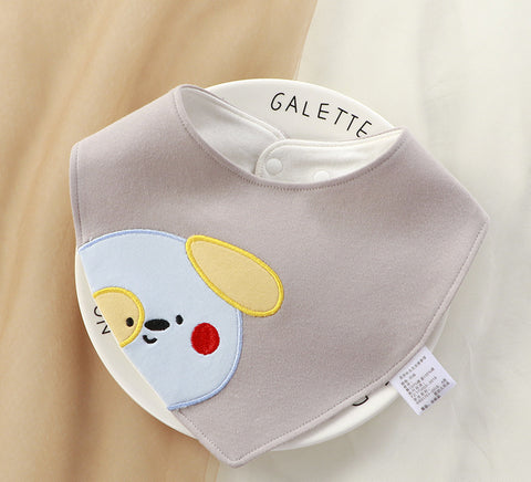 Baby bib with cartoon dog design and 'GALETTE' branding on a beige background