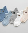 Set of five pairs of socks in blue, gray, white, and beige with animal .