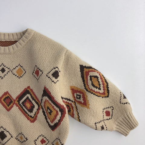 Beige sweater with diamond pattern on a light gray background