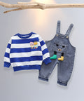 Children's blue and white striped sweater with cartoon design and denim overalls on a light gray background.