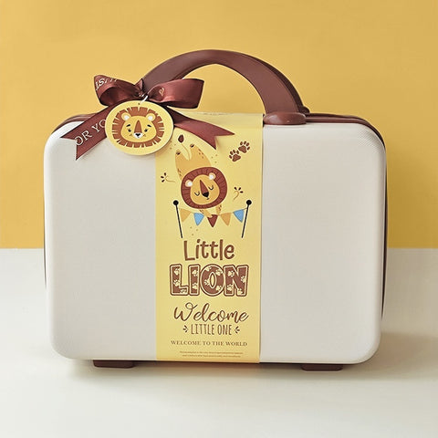 White baby suitcase with a lion-themed decorative tag on a yellow background