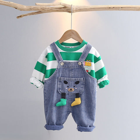 Children's outfit with striped shirt and denim overalls on a hanger against a gray background
