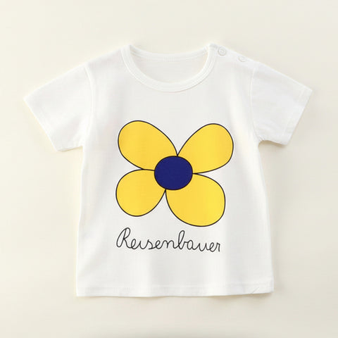 White t-shirt with a yellow flower design and 'Reisenbauer' text on a beige background
