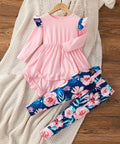 Pink dress with floral leggings on a wooden surface