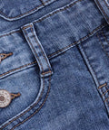 Close-up of blue denim fabric with buttons on a white background
