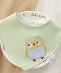 Green baby bib with owl design on a white background