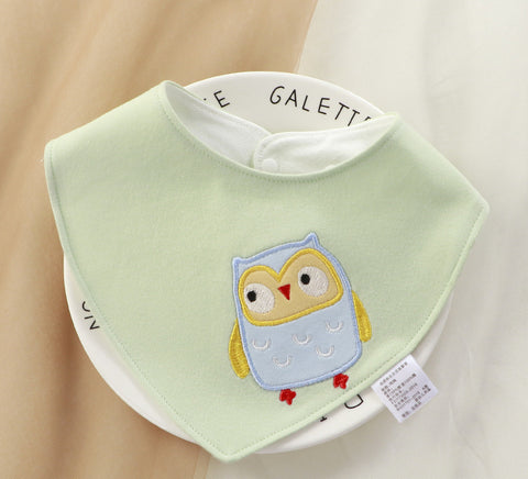 Green baby bib with owl design on a white background