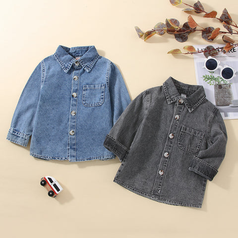 Two denim shirts, one blue and one gray, on a beige surface with decorative elements.
