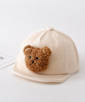 Beige cap with a brown teddy bear patch on a white background