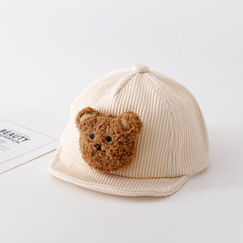 Beige cap with a brown teddy bear patch on a white background