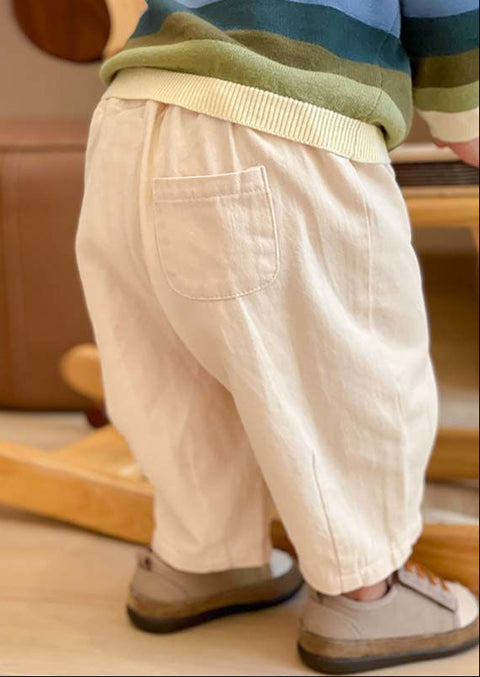 Child wearing beige pants with inset images of gray and white pants.