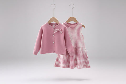Pink cardigan and checkered dress on hangers with a quote below.