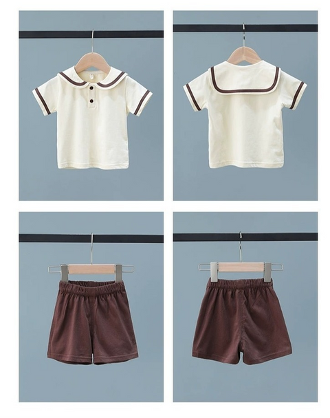 Children's outfit with white polo shirt and brown shorts on hangers against a gray background.