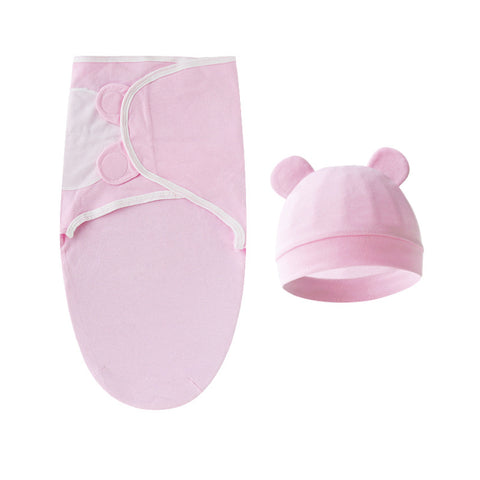 Pink baby swaddle and hat set on a white background